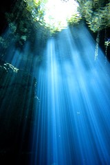 Beautiful beams of light in a Cave and Cavern during a Scuba Diving exploration of a sinkhole or Cenote in the riviera Maya, Mexico