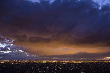 City lights illuminate the bottom of dense clouds over Tucson, Arizona.