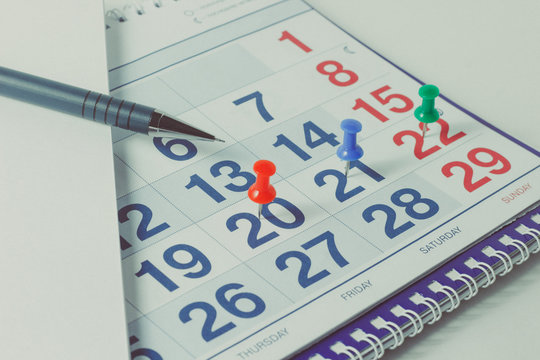 Wall calendar and pen, important days are marked with knops