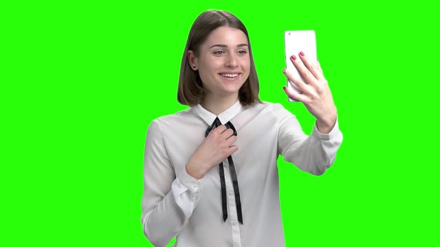 Girl having online video coversation on smartphone. Emotional positive cute woman. Green screen hromakey background for keying.