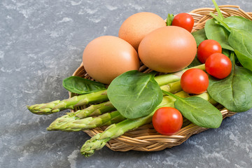 Ingredients for cooking frittata with asparagus, cherry tomatoes and spinach