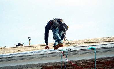 Naklejka na ściany i meble Handyman working on repairing the roof