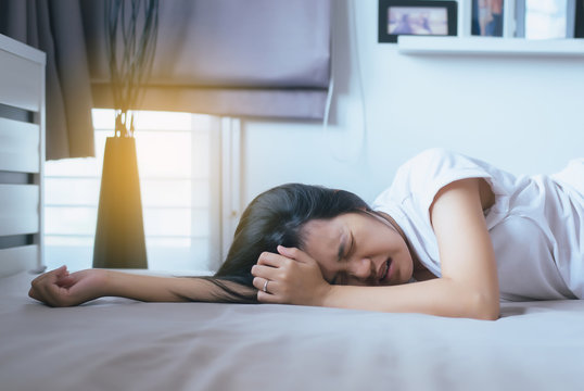 Asian woman have a headache on bed after wake up in the morning