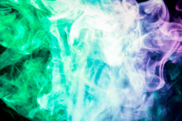 Colorful  green  and purple smoke  on a black isolated background. Background from the smoke of vape