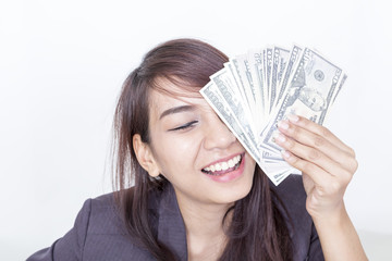 Businesswoman in suit in her office and holding money in hand near smiling  face.