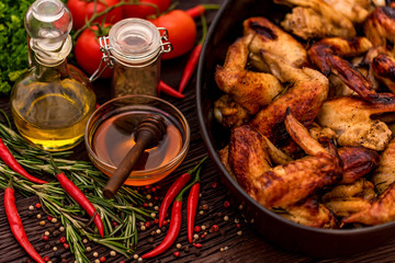 Baked chickens wings covered in honey, vegetables