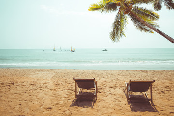 Couple beach chair on tropical beach. vintage color tone effect