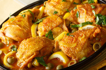 Moroccan cuisine: Spicy chicken with salted lemons, onions and green olives close-up. horizontal