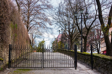 metal gates on the street of old town. lovely scenery with lanterns. location Zhupanatska street, Uzhgorod, Ukraine