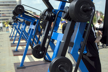 Fototapeta na wymiar Blue outdoor gym machine for street workout standing outside. The concept of healthy lifestyle, street workout.