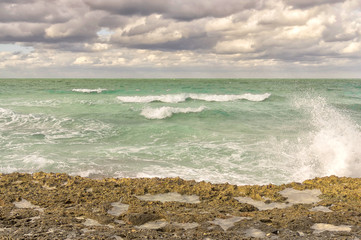 Fototapeta na wymiar The sea wave splits into splashes of the shore