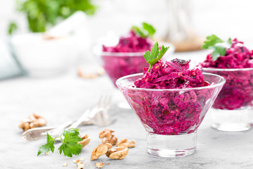 Beet salad. Salad of boiled beet. Beetroot salad with prune, walnuts and sour cream on white background