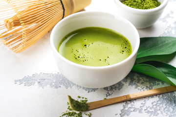Green matcha tea drink and tea accessories on white background