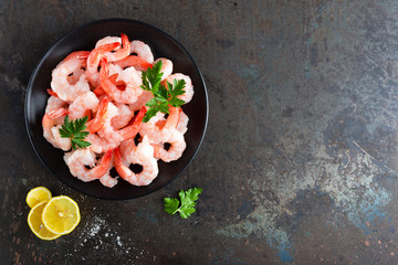 Prawns on plate. Shrimps, prawns. Seafood. Top view. Dark background