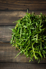 Fresh rucola with water droplets on a dark rustic background