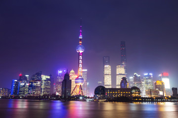 Obraz premium Nowoczesne drapacze chmur w Szanghaju w nocy z odbiciem pięknego światła w widokiem na rzekę Huangpu z bund, Szanghaj, Chiny