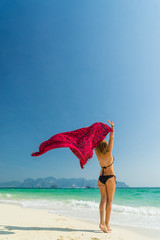 Woman with pink sarong on the tropical beach