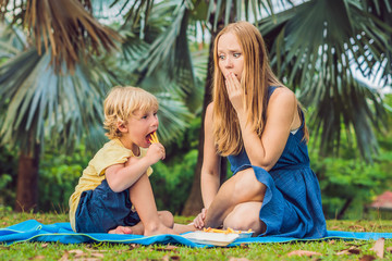 Cute healthy preschool kid boy eats french fries potatoes with ketchup with his mom. child eating...