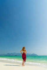 Fototapeta na wymiar Woman with pink sarong on the tropical beach