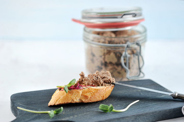 a sandwich of burnt toast with pate and herbs
