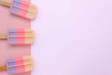 Table top view shot of arrangement food object background concept.Flat lay of colorful ice cream on the modern rustic pink paper at home office desk wallpaper.pastel tone creative design. space text.
