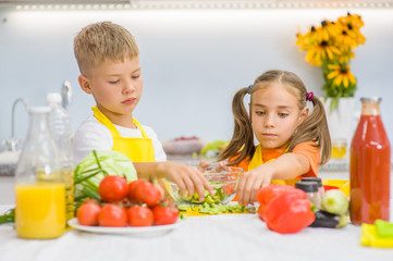 brother with sister preparing for lunch vegetable salad