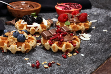 Fototapeta premium Belgian waffles with pomegranate and raspberries, homemade healthy breakfast with mint