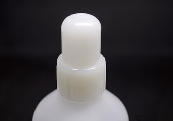 Bottle for medicines, cosmetics of white color, close-up.  On a black background.