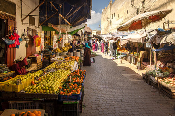 FEZ, MOROCCO - Februari 25, 2018: Fruit marking in the old Medina of Fez city dutring a sunny day - obrazy, fototapety, plakaty
