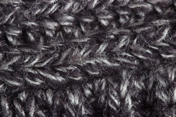 Fragment of a gray knitted woolen sweater close-up.