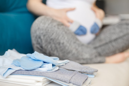 pregnant woman preparing baby clothes