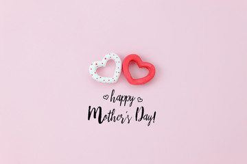 Top view aerial image of decoration Happy mother’s day holiday background concept.Flat lay sign of season couple heart shape on pink paper at home office desk with creative design text for seasonal.