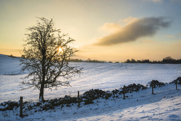 Beautiful snow covered Winter landscape at sunrise in Peak District in England