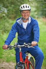 Senior Man Enjoying Cycle Ride In The Countryside