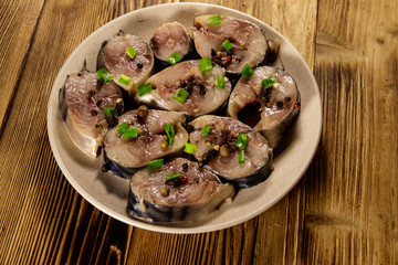 Sliced mackerel with spices on wooden table. Salted scomber on a plate