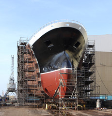 New big ship on dry dock in shipyard.