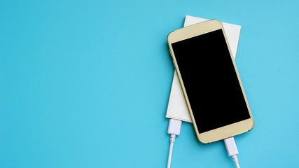 smartphone and power bank for charging mobile devices on a blue background.