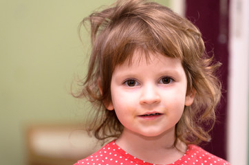 A small three-year-old European girl is smiling. Picture of the face, portrait.
