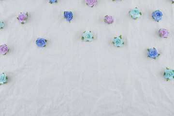 Obraz na płótnie Canvas Blue tone rose paper flowers pattern on muslin fabric with copy space
