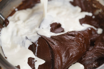 adding cream into melted chocolate