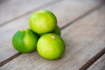 Fresh green lemon on wood table.