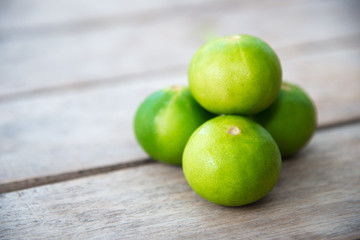 Fresh green lemon on wood table.