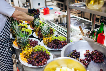 cooks lay out grapes and pineapples