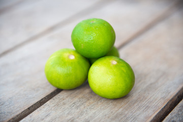 Fresh green lemon on wood table.