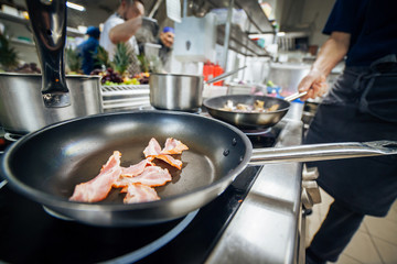hot bacon pieces on the frying pan