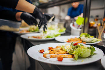 chef decorates the salad with greens