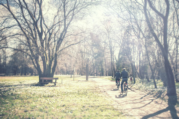 retired couple is cycling, two adults are riding a bicycle vintage effect