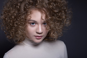 Portrait of a beautiful teenage girl with a creative make-up and Afro-curls .