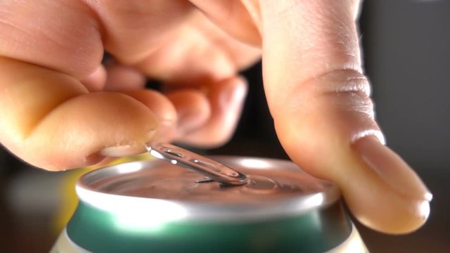 Close up of hand opening a beer can in slow motion