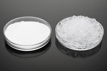 hydro-gel powder and jelly-like, swollen from water, large pieces in glassware on a dark surface